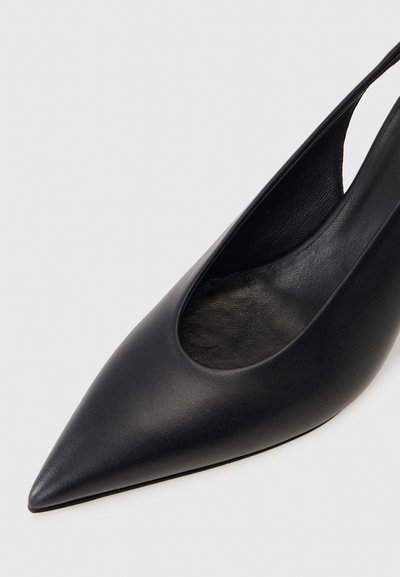 Μαύρο δερμάτινο παπούτσι slingback με μυτερή μύτη, χαμηλή κοπή στο πάνω μέρος και λεία υφή, σε απλό φόντο.