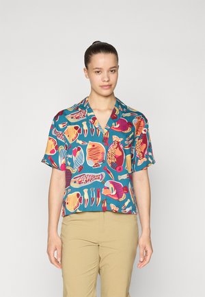Short-sleeve button-up shirt in teal fabric with a colorful fish pattern, featuring various fish shapes in pink, yellow, and blue.