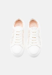 Λευκά sneakers με δαντέλα και υφασμένο άνω μέρος, με λείο ελαστικό πέλμα και έξι οπές για τα κορδόνια. Περιλαμβάνει διακριτικό λογότυπο στη γλώσσα.