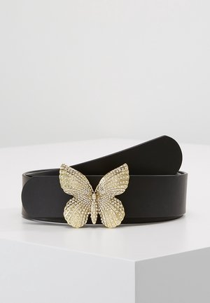 Black leather belt with a large gold butterfly buckle adorned with small clear rhinestones resting on a white surface.
