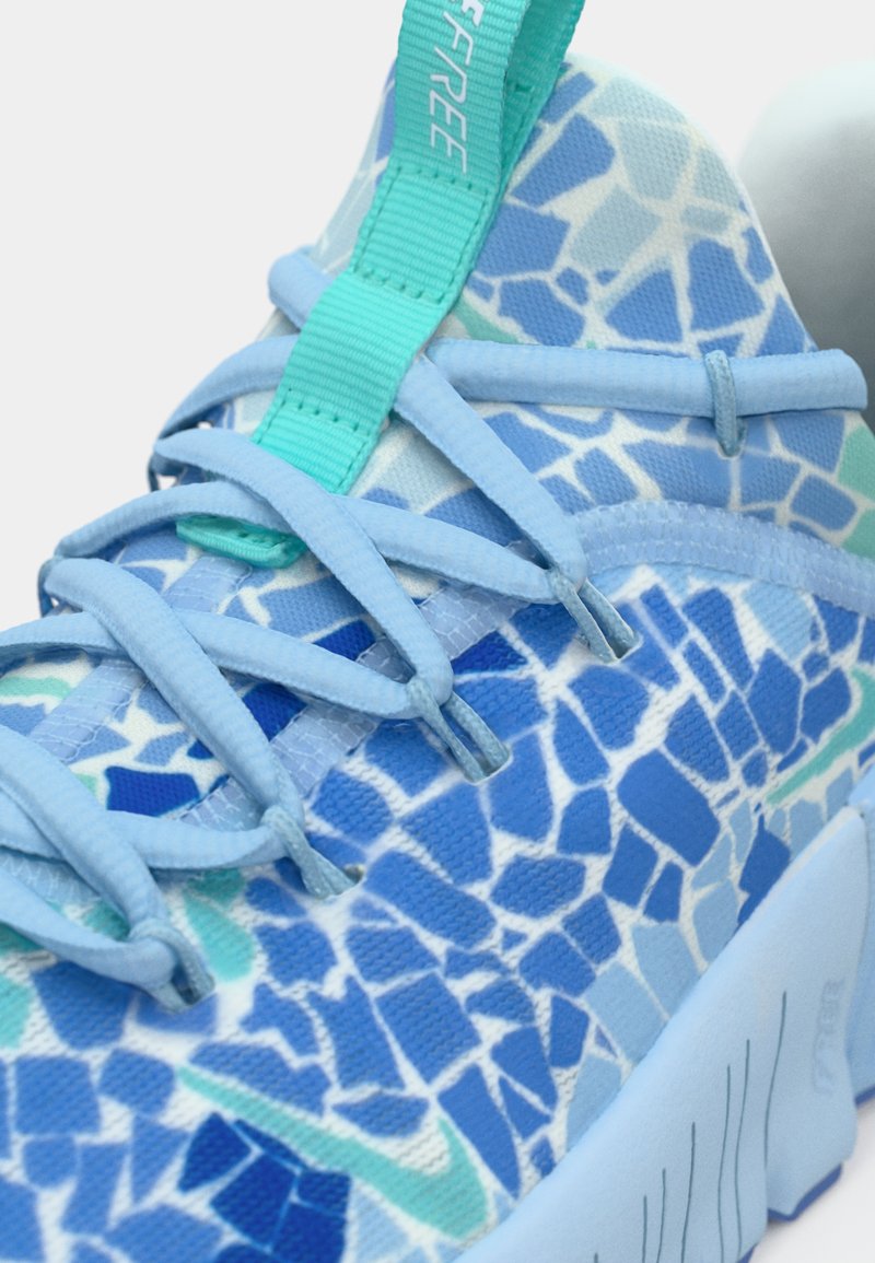 Helleblaue Sportschuh mit einem Mosaikmuster in verschiedenen Blautönen. Verfügt über ein strukturiertes Obermaterial, eine flexible Sohle und türkisfarbene Akzente an den Schnürsenkeln.