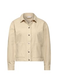 Béžová kordurová bunda s knoflíkovou přední částí, dvěma předními kapsami a límcem. Texturovaná látka a přiléhavé manžety dodávají detail.