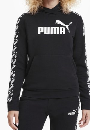 Schwarzer Puma-Hoodie mit weißem Logo auf der Brust und gemusterten Logostreifen entlang der Ärmel, getragen mit passenden schwarzen Puma-Hosen.