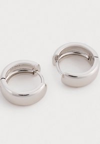 Pendientes de aro de plata con un acabado suave y pulido. Forma circular con apertura de bisagra, que presenta una sutil textura interior.