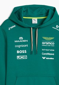 Sweat à capuche vert avec Aston Martin et divers logos de sponsors, notamment TikTok, Maaden, Cognizant, Boss, JCB, Aramco, Honda, CoreWeave et Valvoline.