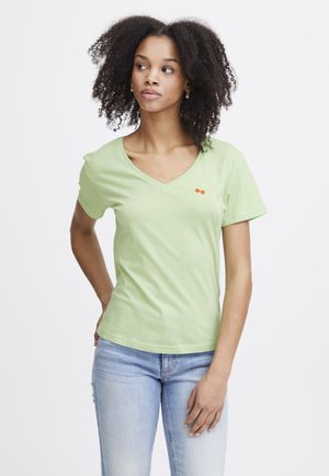 Lichtgroene katoenen t-shirt met een v-hals, korte mouwen en een klein rood kersenprintje op de linkerborst. Klassieke pasvorm, zachte textuur.