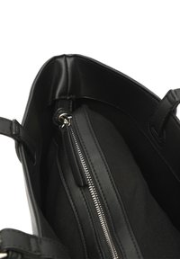 Borsa a tracolla in pelle nera con scomparto interno con zip, cuciture visibili e due manici su sfondo bianco.