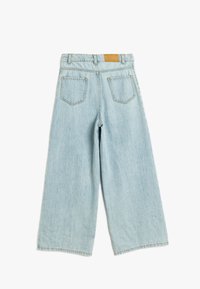 Jeans de mezclilla de corte ancho en azul claro, con cintura alta, dos bolsillos traseros y un parche de cuero color tostado en la cintura.