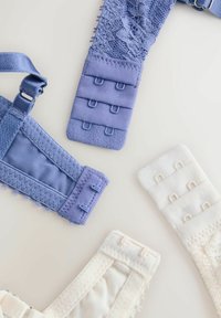 Bretele albastre și albe pentru sutien, cu închideri cu trei cârlige și detalii din dantelă, așezate pe o suprafață deschisă la culoare.