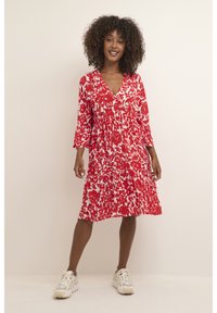 Rotes und weißes Blumenkleid mit V-Ausschnitt, dreiviertelärmeln und gerafftem Bund. Der Stoff scheint leicht und mit einer weichen Textur zu sein.