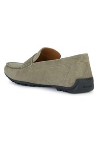 Mocasines de ante gris con suela de goma negra, diseño slip-on, punta redondeada, detalles de costura sutiles y marca GEox en el talón.