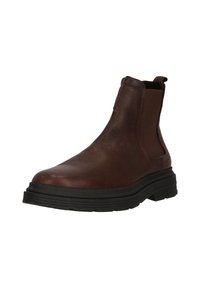 Bruine leren enkelboot met elastische zijpanelen, textuur bovenkant en een dikke zwarte rubberen zool. Voorzien van een trekband voor gemakkelijk aan- en uittrekken.