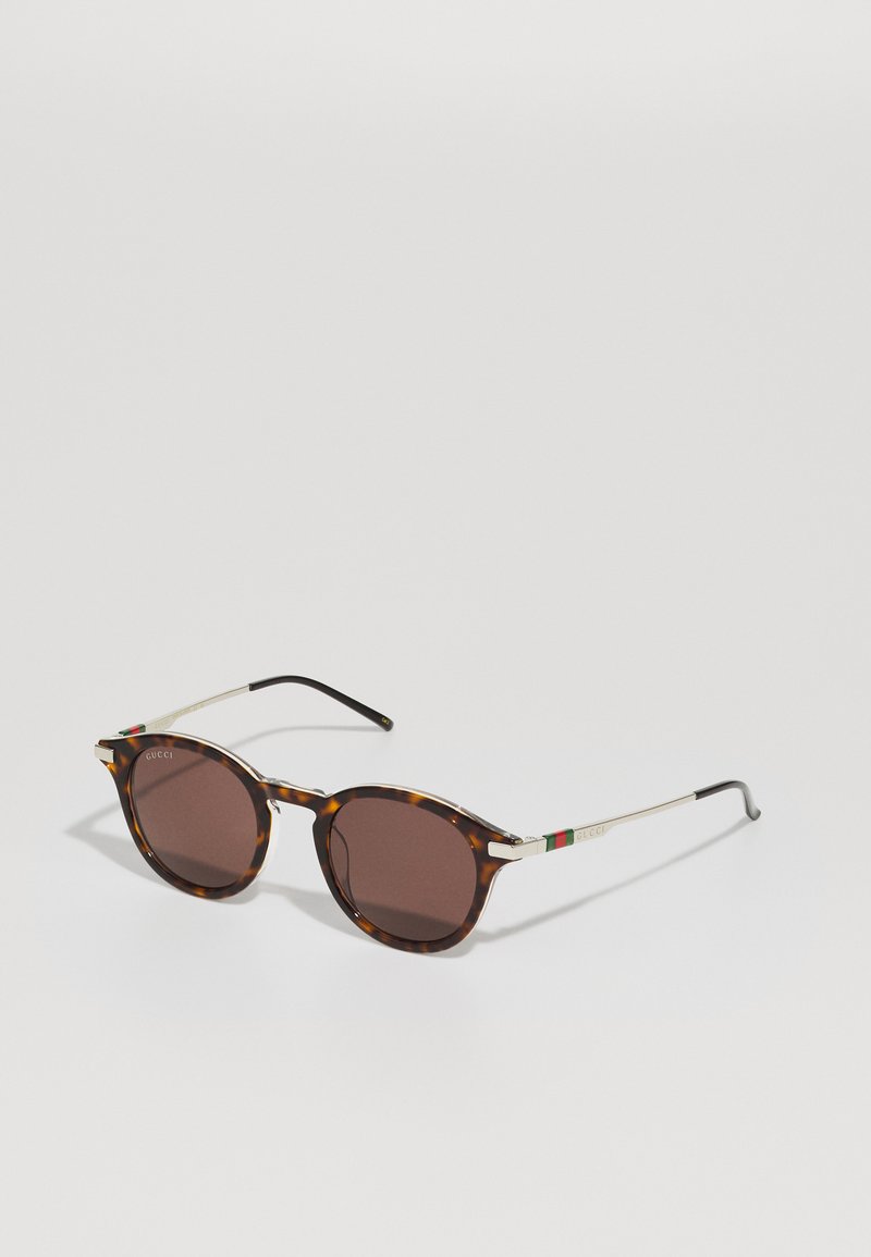 Tortoiseshell sunglasses with round lenses, gold accents on the temples, and a tri-color band featuring green, red, and white detail.