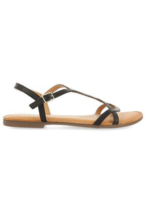 Sandali neri con cinturini e suola piatta, dotati di chiusura a fibbia e una soletta marrone, progettati per comfort e stile.