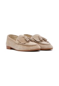 Mocassini in suede beige con un nastro decorativo sulla parte anteriore, dettagli cuciti e un tacco basso marrone. Colore uniforme, texture liscia.