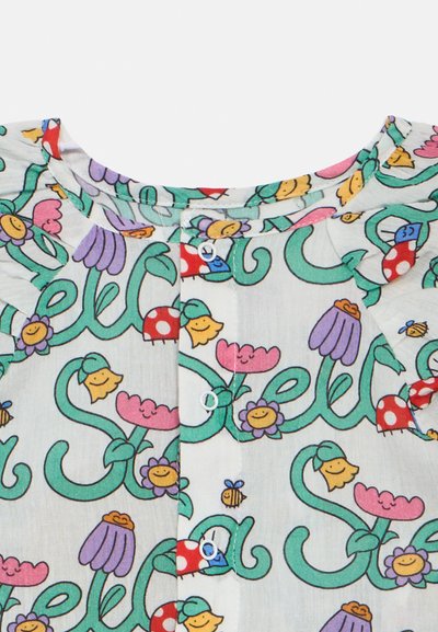 Könnyű anyagú ing, amely sokszínű virágos és rajzfilmes mintákkal, valamint zöld indákkal díszített. Kerek nyakkivágás, gombos záródás és játékos dizájnelemek jellemzik.