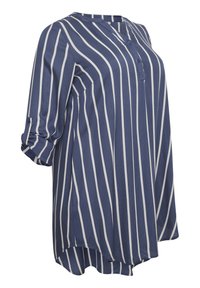 Blouse rayée bleu et blanc avec un col en V, une patte de boutonnage à trois boutons, des poignets retroussés et un ourlet asymétrique. Fabriquée en tissu léger.