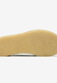 Sole gialla con texture, bordi arrotondati e una leggera curvatura. Finitura liscia e un motivo sottile sono visibili sulla superficie.