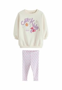 Felpa color crema con illustrazioni di gatti e dettagli viola, abbinata a leggings rosa a pois. Tessuto morbido, polsini a coste e orlo arricciato.