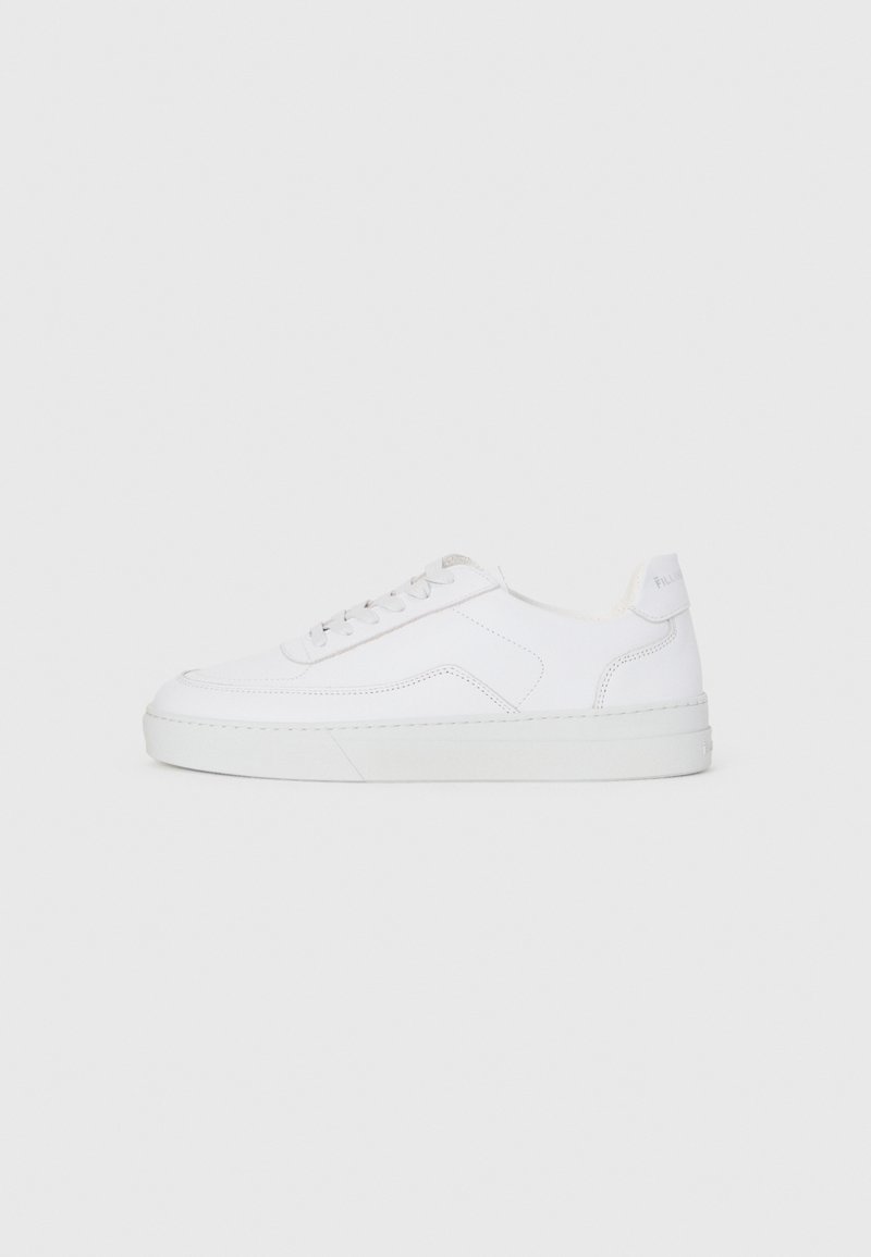 Sneaker bassa bianca con lacci, tomaia liscia e suola in gomma su sfondo chiaro.