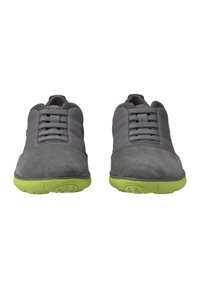 Grijze sportieve schoenen met een bovenwerk van suede en mesh, voorzien van een vetersluiting en felgroene rubberen zolen. Gladde textuur en ronde vorm.