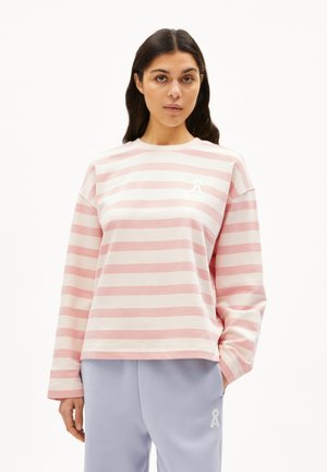 Pink and white striped long-sleeve sweatshirt with a relaxed fit and a small white logo on the chest; paired with light purple sweatpants.