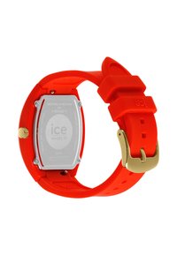 Orologio da polso in silicone rosso con cassa posteriore rettangolare in acciaio inossidabile, hardware dorato e cinturino testurizzato con chiusura a fibbia.