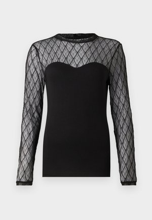 Svart langermet topp med gjennomsiktig mønstret mesh-yoke med diamantformer. Glatt stoff under yoken med bølget halslinning.