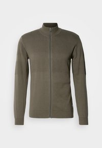 Giacca con zip frontale di colore verde oliva, caratterizzata da pannelli testurizzati, maniche lunghe e colletto rialzato. Realizzata in un tessuto a maglia liscio.