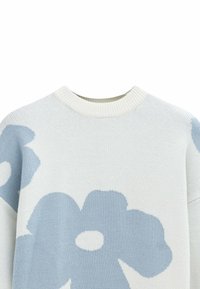 Pull en maille légère de couleur crème avec de grands motifs floraux bleus. Présente un col côtelé et une texture douce.