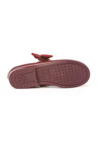 Suela de zapato plano color burdeos con agarre texturizado, sección del tacón marcada con la talla 25, y detalle de lazo parcial visible en la parte superior.