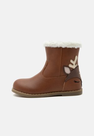 Botte d'hiver marron pour enfants avec bordure en fausse fourrure blanche et détail d'un visage de renne cousu sur le talon.