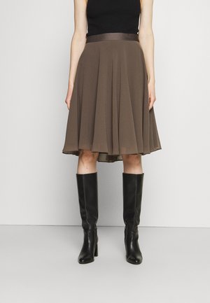 Bruine geplooide rok met een satijnen taille, gecombineerd met zwarte kniehoge laarzen, tegen een neutrale achtergrond. Glad textuur en vloeiend ontwerp.