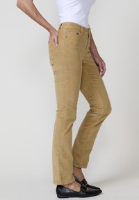 Corduroy broek in een lichttan kleur met een aansluitend ontwerp, vijf-pocket styling en een rechte pijp. Soepele textuur met zichtbare stikseldetails.