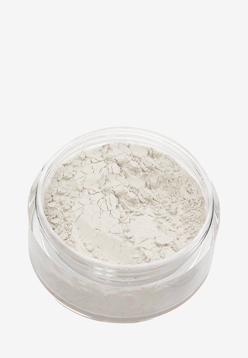 Translucent krukke med fint, lys gråligt pulver. Pulvret har en tekstureret overflade med synlige revner og en glat, mat finish.