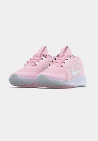 Une paire de chaussures de course Nike roses avec des logos Swoosh blancs, tige en maille et semelles blanches, présentée de face sur un fond blanc.
