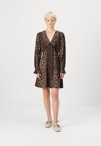 Vestido de estampado de leopardo com decote em V, mangas longas e punhos franzidos. O tecido é leve, apresentando tons de castanho escuro e bege.