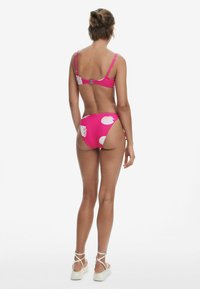 Roze bikini met witte schelpprint; verstelbare schouderbandjes, haaksluiting op de rug; hoge taille broekjes, soepele textuur.