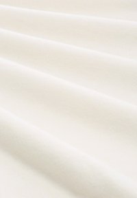 Tissu blanc avec une surface douce et texturée, affichant de subtils plis et une finition lisse, adapté à diverses applications textiles.