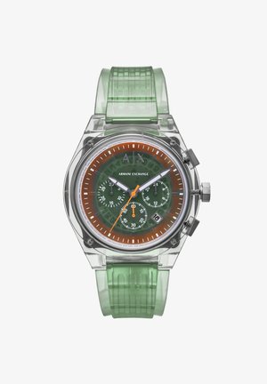 Priehľadné, osmihranné hodinky s priesvitným puzdrom, zeleným silikónovým remienkom, hnedo-oranžovým ciferníkom, bielymi znameniami a tromi subciferníkmi.