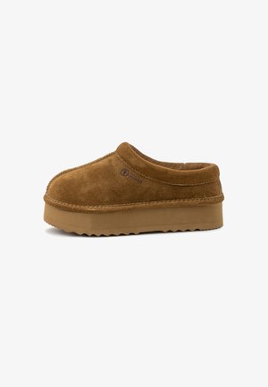 Sabot à enfiler en suede marron avec une surface texturée, un col rembourré et une semelle en caoutchouc épaisse avec un bord cranté. Logo embossé sur le côté.