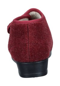 Red felt slipper with a round back, textured surface, and black rubber sole. Features a padded rim for comfort and a simple design.
