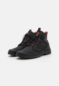 Bottines noires avec une finition texturée et des accents oranges. Dotées d'un système de laçage rapide et de semelles en caoutchouc, conçues pour la durabilité et le confort.