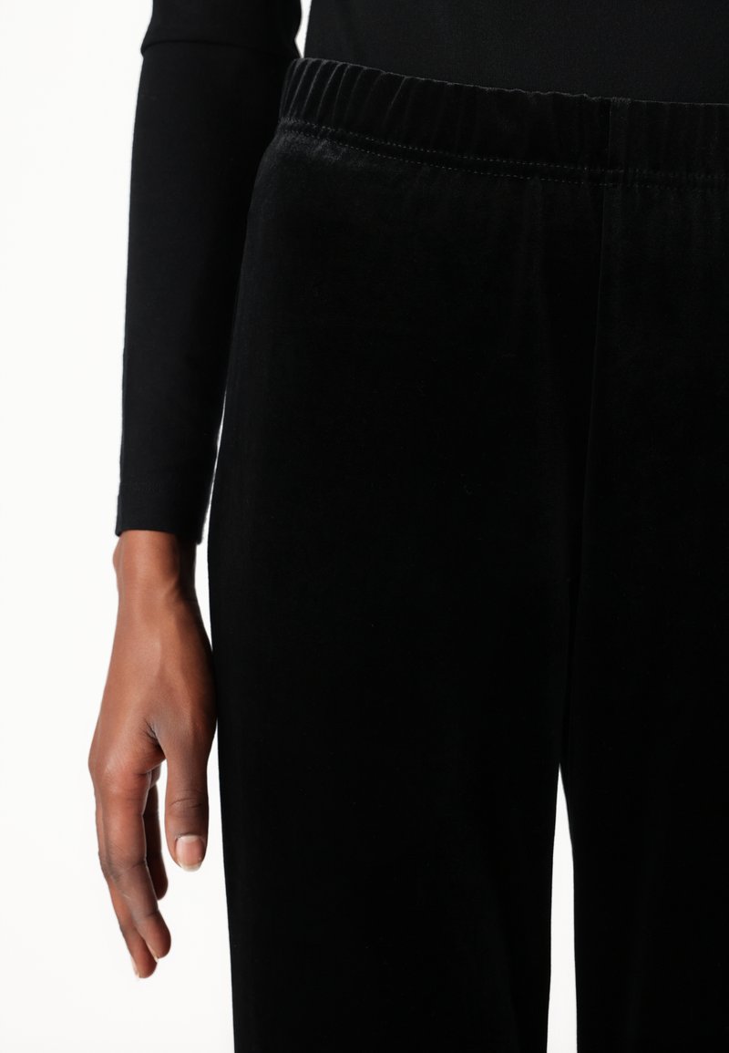 I joggers in velluto nero presentano un vita elastica e un design slim-fit. Il tessuto ha una texture morbida con una finitura liscia.