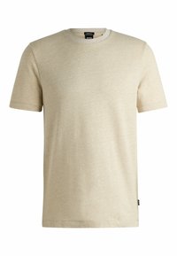 T-shirt beige a maniche corte realizzato in un tessuto morbido e testurizzato. Presenta un collo a giro e un delicato motivo melangiato. Etichetta del marchio visibile.
