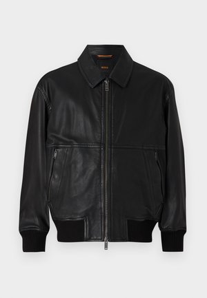 Black leather bomber jacket with a zip front. Features ribbed cuffs, a flat collar, and two side zip pockets. Smooth texture, classic design.