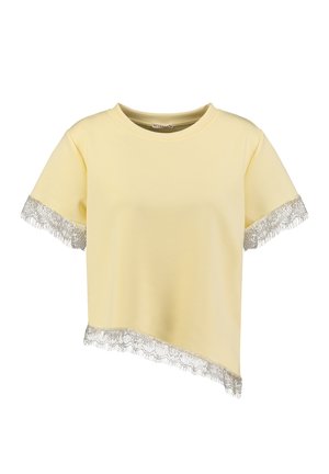 Geel crop top met korte mouwen, asymmetrische zoom en zilveren kanten bies op de mouwen en onderkant.