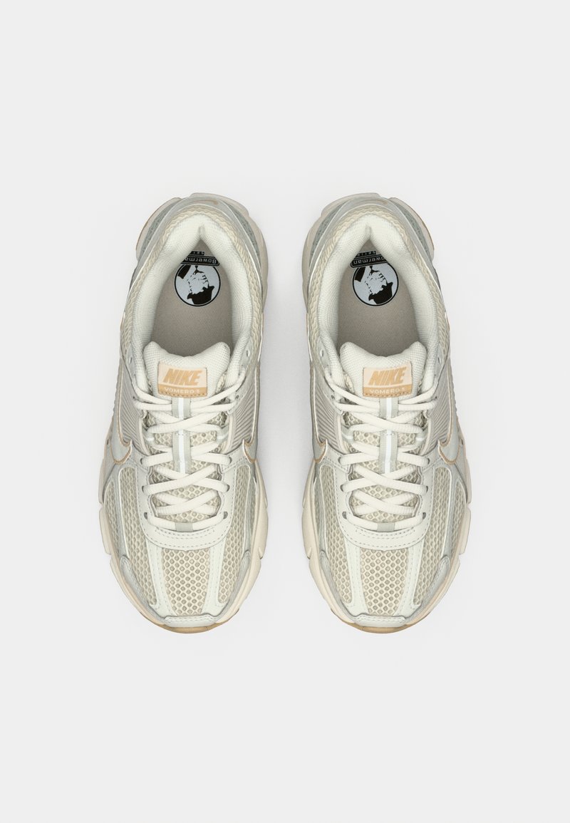 Weiße Nike-Sneakers mit Mesh- und Synthetikobermaterial, runder Zehenform, Schnürverschluss und dezenten reflektierenden Akzenten.