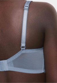 Soutien-gorge azzurro con pannello in rete; include spalline regolabili, chiusura a gancio e bordi ondulati. Texture liscia.