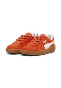 Suede tenisice u narančastoj boji s bijelim detaljima. Zaobljeni vrh, zavezivanje, i teksturirana gumena potplata. Sadrži Puma logotip sa strane.